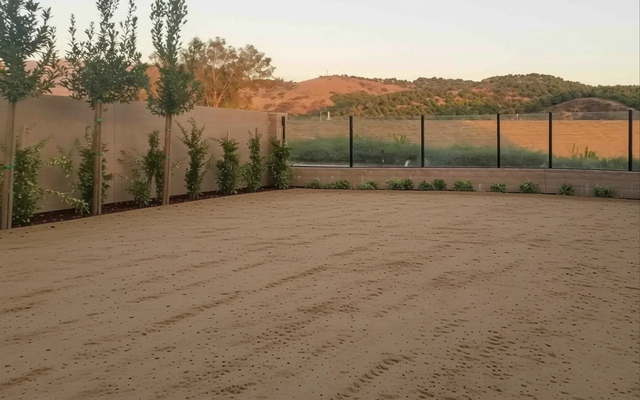 AI visualization of the same yard before construction: bare dirt behind the view fence