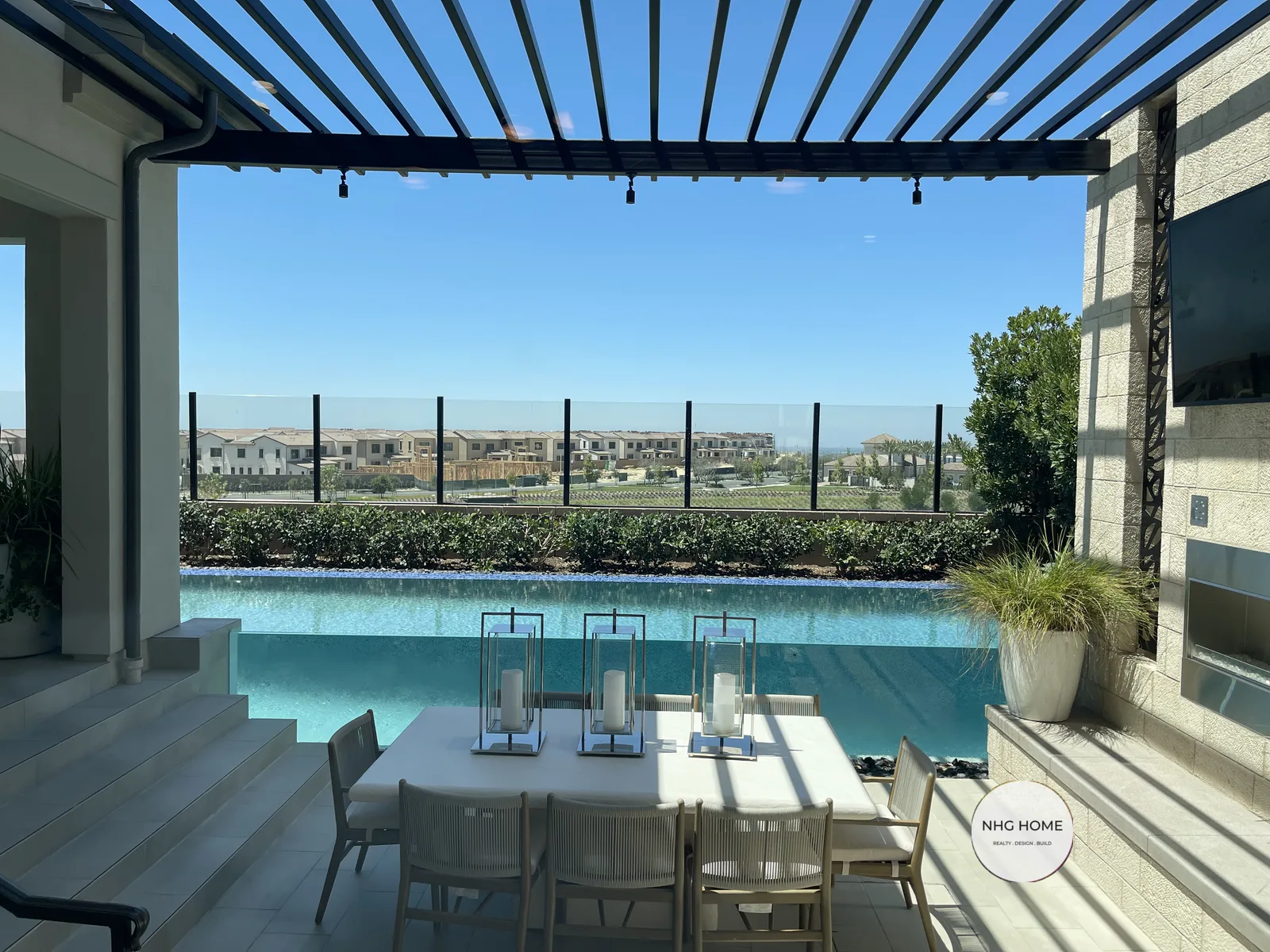 Covered outdoor dining terrace with louvered pergola and pool by NHG HOME